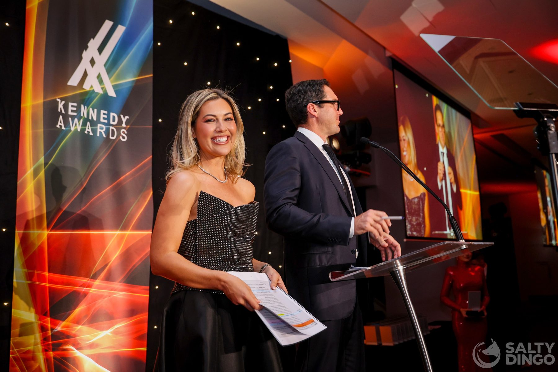Gabriella Power and Peter Stefanovic hosting the 2026 Kennedy Awards on stage